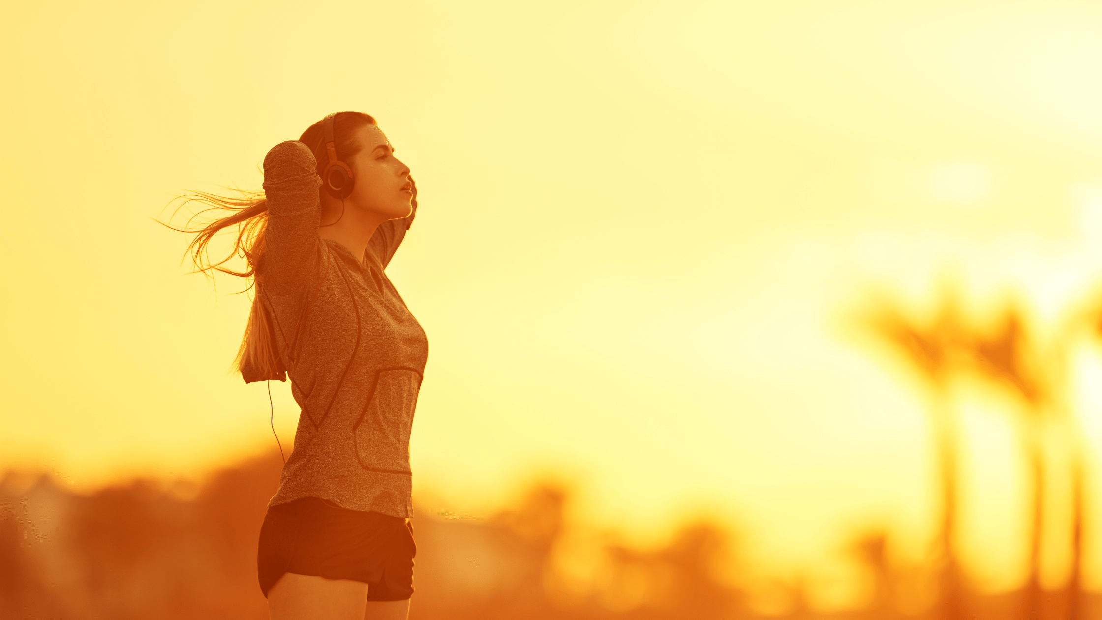 Image of a woman stretching after a run in the evening light of a setting sun - urban setting